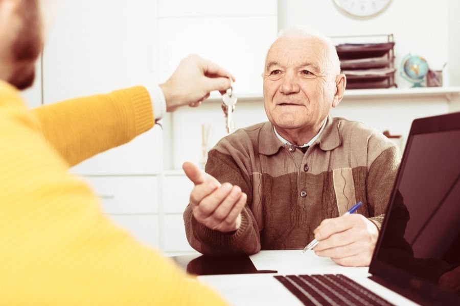 Пенсионеру вручают ключи от нового жилья, полученного в ипотеку