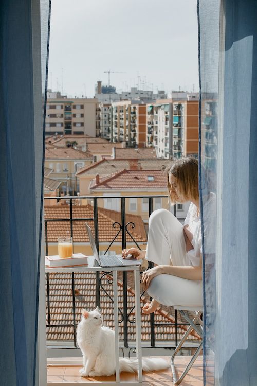 Девушка с ноутбуком на балконе